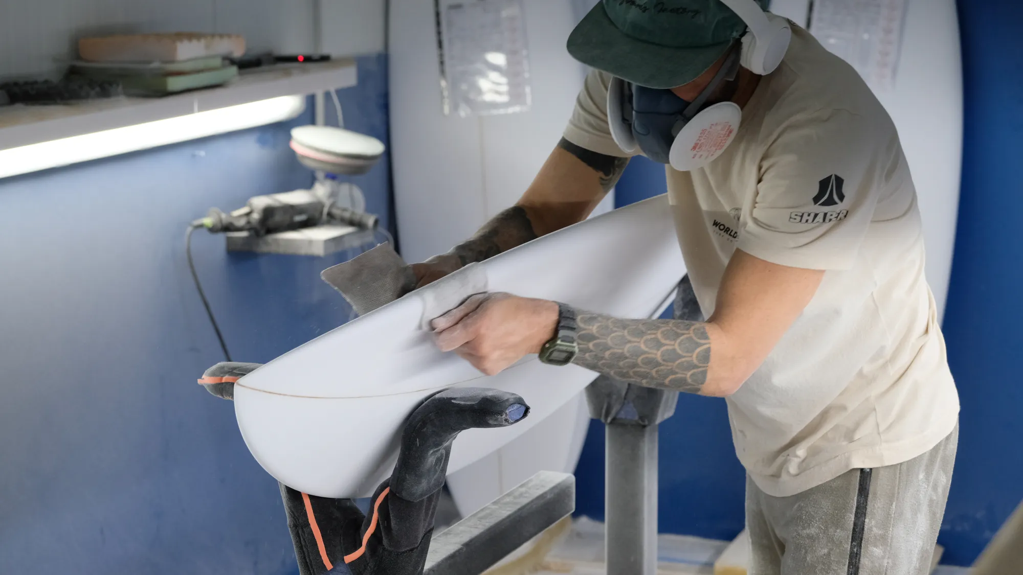 Finition au rabot d'un rail de planche de surf dans l'atelier World Shapes