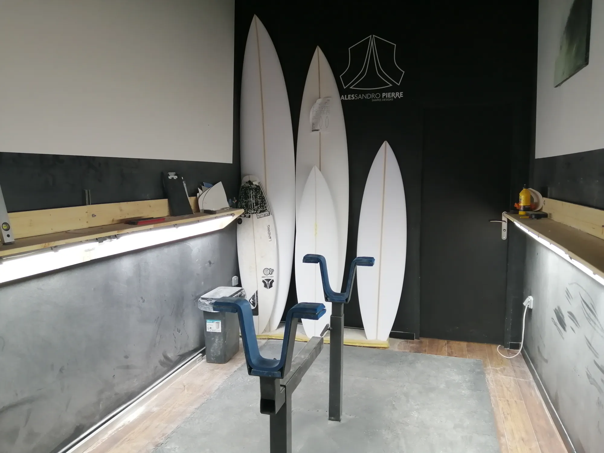 Shape room Alessandro Pierre, planches blanches sur rack avec logo AP au mur