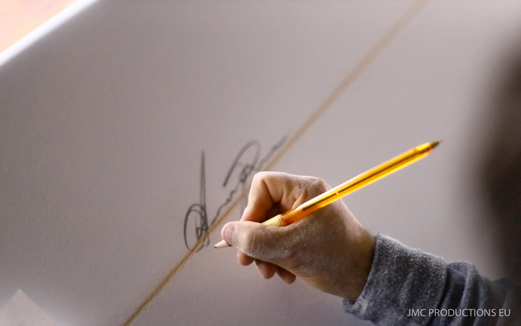 Alessandro Pierre signant une planche de surf au stylo doré, chaque planche est signée à la main