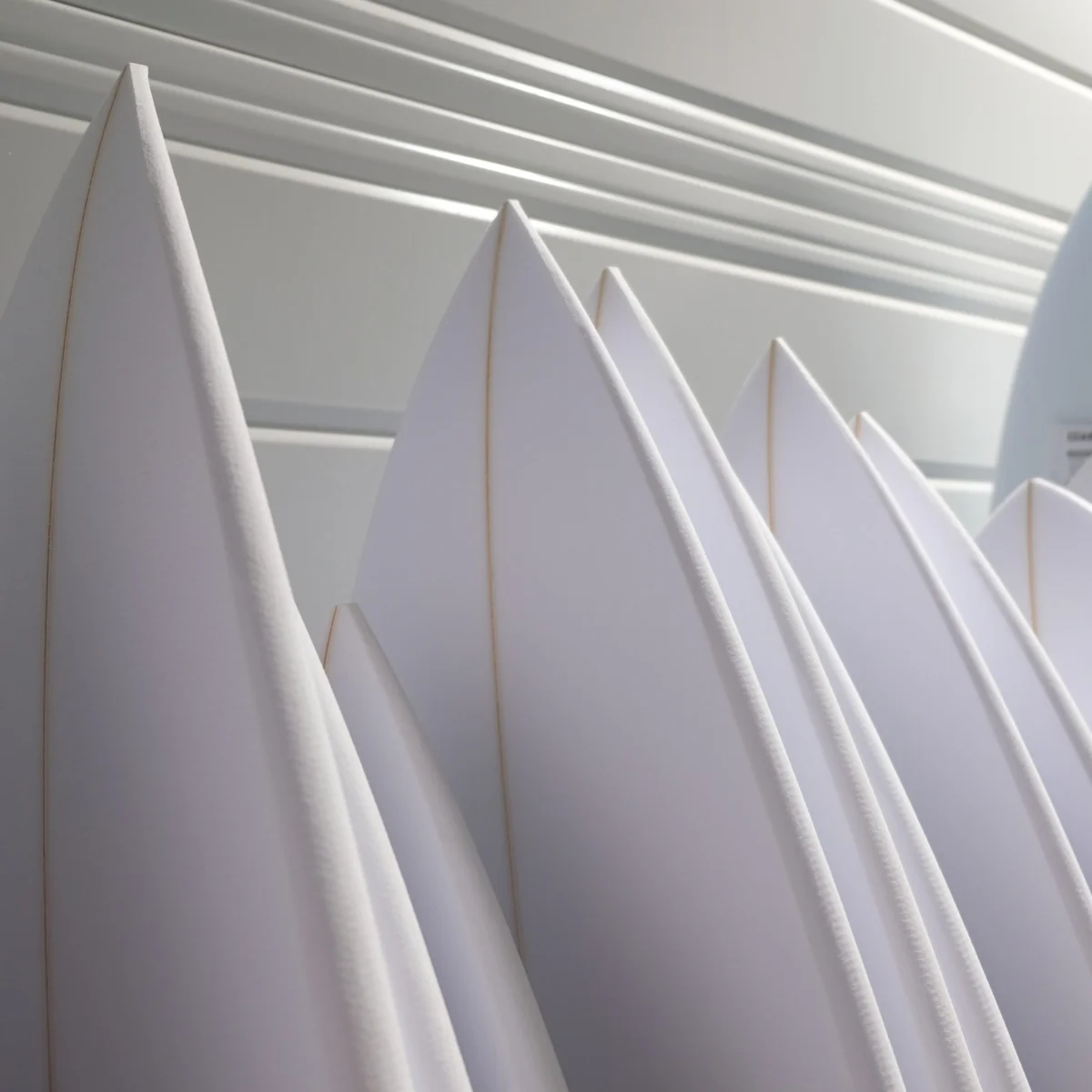Planches de surf Alessandro Pierre alignées dans l'atelier