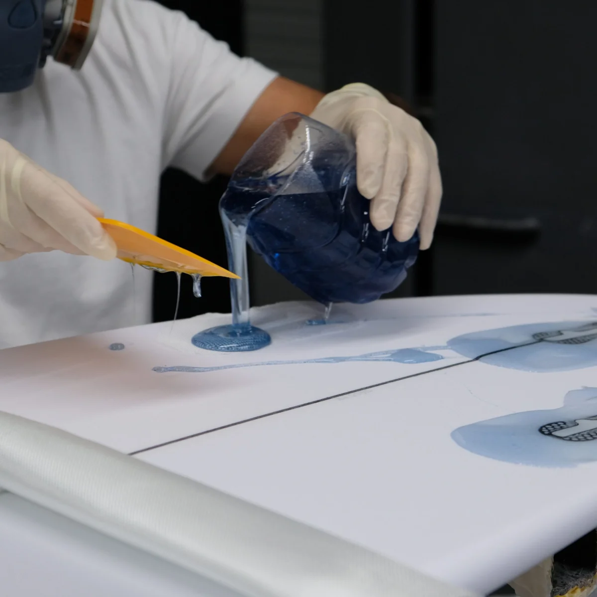 Lamination résine bleue versée sur planche de surf