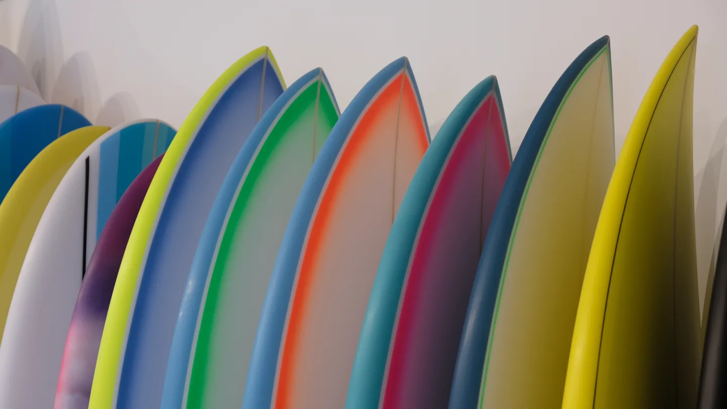 Nez de planches de surf aux couleurs vives : vert, bleu, rose, jaune